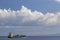 cargo ship nearby Capo Peloro Lighthouse in Punta del Faro on the Strait of Messina, most north eastern promontory of Sicily,