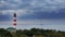 Cargo ship passes by a beautiful majestic lighthouse