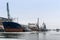 Cargo ship in the port near the pier in winter among the ice