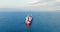 Cargo ship sailing toward industrial business harbor during foggy sea sunrise, aerial view of seascape and cityscape