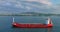 Cargo ship sailing toward industrial business port during sea sunrise with stormy cloudscape