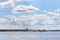 Cargo ship sails on river with coastline with sand