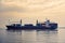 Cargo ships transporting containers in the evening light. Concept of transport and commerce by sea. Lisbon, Portugal. Europe