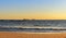 Cargo ships travel on the ocean horizon in the beautiful evening near the Galle beach. Scenic landscape photograph