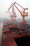 Cargo terminal for discharging coal cargos by shore cranes during foggy weather. Port Bayuquan,China.