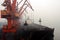 Cargo terminal for discharging coal cargos by shore cranes during foggy weather. Port Bayuquan,China.