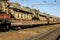 Cargo train carrying military tanks on railway flat wagons