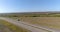 A cargo truck is driving along the highway. View from a drone. The wagon is driving along a curved road between the