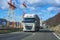 Cargo trucks. Electric poles, mountains and blue sky in the background.