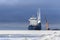 Cargo vessel moored in arctic port. Winter time. Ice navigation. Loading in progress