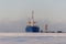 Cargo vessel moored in arctic port. Winter time. Ice navigation. Loading in progress