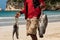 Caribbean fisherman walking on a beach in the Dominican Republic, selling freshl fish, just caught. Amazing turquoise sea, typical