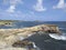 Caribbean landscape with turquoise waters and waves breaking over volcanic rocks