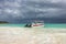 Caribbean sea before the rain. Boat with two people moored at the shore. Clouds. Turquoise water