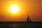 Caribbean sea sunset in orangy tones with sailboat