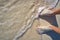 Caribbean tourist male feet on white sand shore