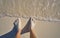 Caribbean tourist male feet on white sand shore