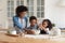 Caring African American mother with little kids cooking together