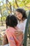 Caring Asian grandmother tells a story to her granddaughter while relax on a bench in the park