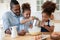 Caring biracial dad and little kids making pancakes