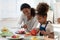 Caring biracial mom teach little daughter cooking in kitchen