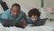 Caring black dad teaching son using laptop at home