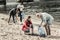 Caring blonde-haired teacher helping her students volunteering at the beach