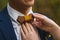 Caring bride straightening wooden bow tie to groom
