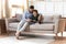 Caring dad rest on sofa with little son using cellphone