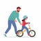 Caring dad teaching little daughter in helmet to ride balance bike for first time. Father helping girl kid riding bicycle