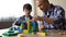 Caring daddy and his smiling son playing colored toy cubes at home, childhood