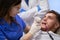 Caring dentist lady fixing her patientâ€™s teeth