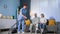 Caring for elderly, a female social worker helps an elderly married couple with housework and vacuums room, smiles and