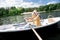 Caring elderly husband helping his wife holding paddle sitting in boat