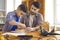 Caring father carpenter in the workshop teaches his little interested son to make a wooden house.