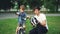 Caring father is holding bicycle helmet and talking to his adorable son explaining safety regulations while boy is