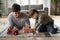 Caring father play cars with small son at home