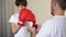 Caring father putting on son arms boxing gloves and teaching to defend himself