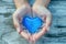A Caring Gesture Hands Cradling A Heartfelt Blue Symbol Of Love