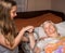 Caring girl holding old lady\'s hands