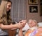 Caring girl holding old lady\'s hands