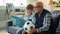 Caring grandad and happy boy watching football on TV holding foam hand and ball