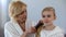 Caring grandmother combing granddaughter hair in front of mirror, family love