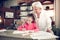 Caring grey-haired granny hugging her cute girl writing letters