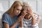 Caring grownup daughter soothes mature mother showing care and support