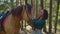 Caring horsewoman stroking her horse outdoors