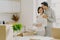 Caring male embraces his wife with love and tenderness, kisses in head, pose together in kitchen, move into new rented flat,