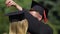 Caring male graduate adjusting tassels on girlfriend\'s cap, couple in love