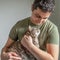 Caring Man Holding Cute Tortoiseshell-Tabby Cat