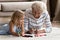 Caring mature granny teaching interested granddaughter preschooler to draw sketches